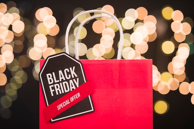 Photo black friday inscription on red paper shopping bag