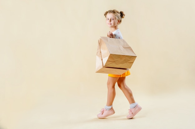 Black Friday. Little blonde girl holds craft packages 