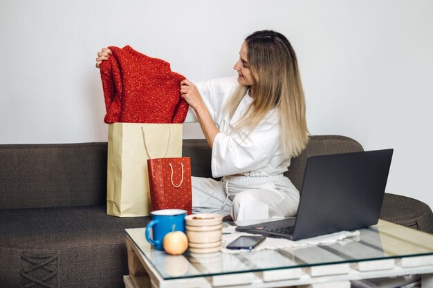 Black friday online sale internet shopping ecommerce caucasian woman pulls new clothes out of