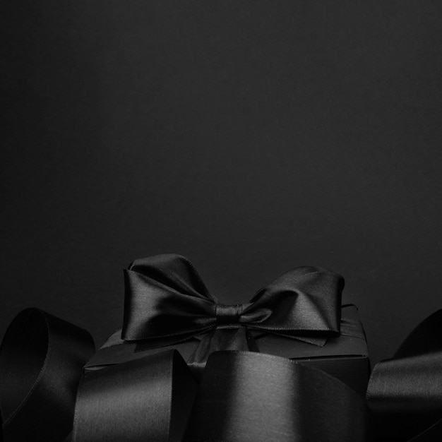 텍스트 광고를 위한 복사 공간이 있는 선물 선물 상자와 곱슬 리본이 있는 검은 금요일 판매 배경