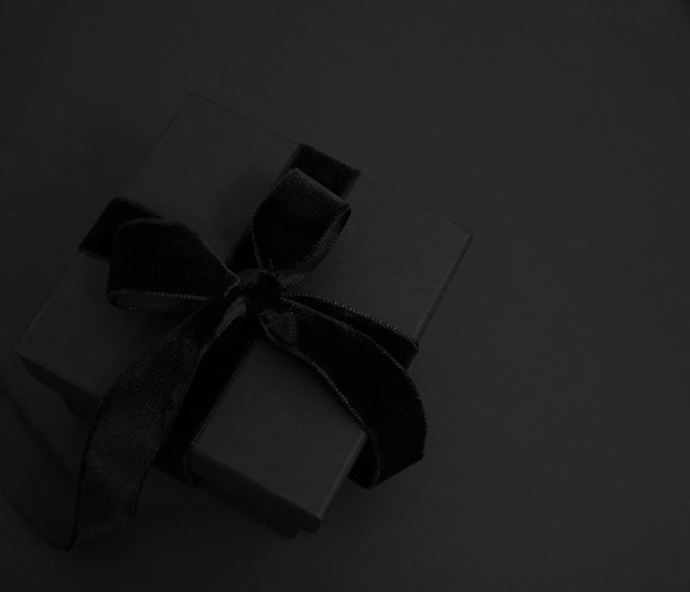 블랙 프라이데이 세일 (Black Friday Sale) 은 블랙  뷰에 고립된 리본 활이 있는 블랙 기프트 박스이다.