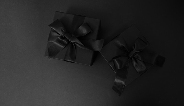 블랙 프라이데이 세일 (Black Friday Sale) 은 블랙  뷰에 고립된 리본 활을 가진 검은 선물 상자입니다.