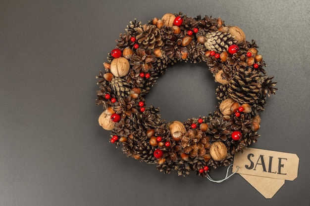 Black Friday Sale concept. Autumn wreath with handmade paper tag. Black stone concrete background, flat lay, top view