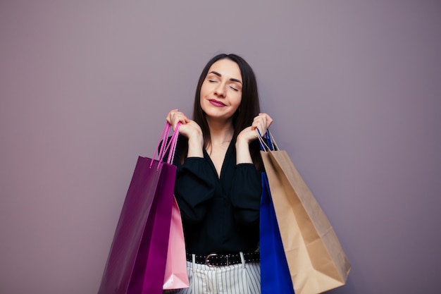 Black Friday sale concept for the store. Shopping woman in sunglasses holding bag isolated on dark surface.