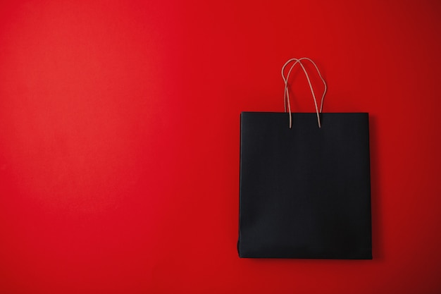 Фото Черная пятничная распродажа, черная пятничная сумка на красной поверхности,