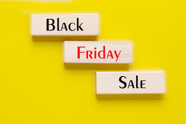 Black Friday Sale in tekst op houten blokken op gele achtergrond