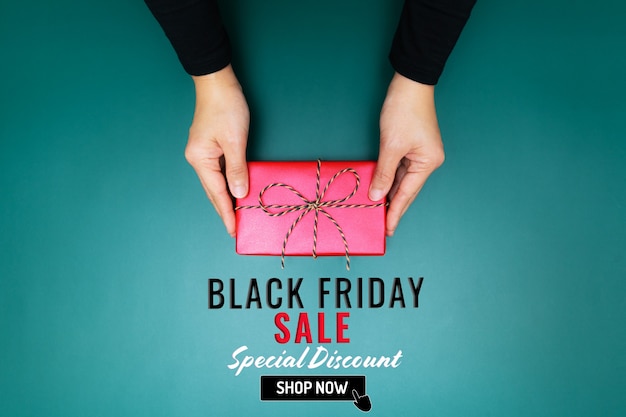 Black Friday Sale, jonge vrouwenhand met een geschenkdoosaanbieding aan de ontvanger