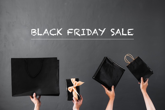 Black Friday Sale of online winkelpromotieconcept met handen opheffende boodschappentas of een geschenk