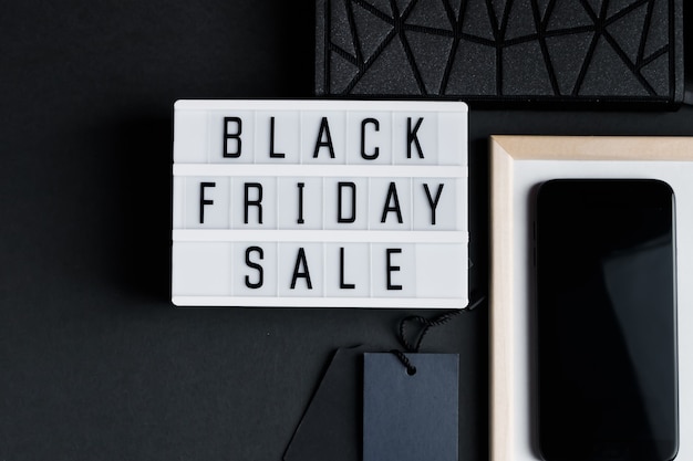 Black friday saldi smartphone e accessori su sfondo scuro flatlay monocromatico