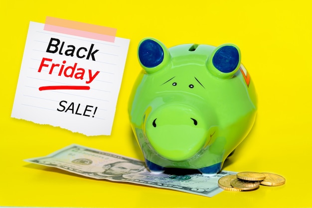 ブラックフライデーの貯金メッセージ、貯金箱、ブラックフライデーのテキストが書かれたカード。ショッピングセールのコンセプト