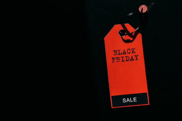 검은 금요일 쇼핑 판매 개념. 검은 나무 바탕에 빨간색 태그에 텍스트