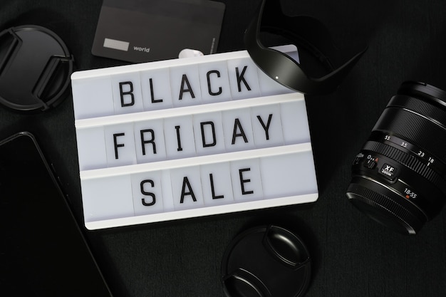 Black friday word written on lightbox on black textile. Flat lay, top view