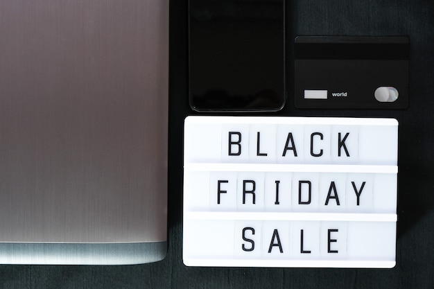 Photo black friday word written on lightbox on black textile