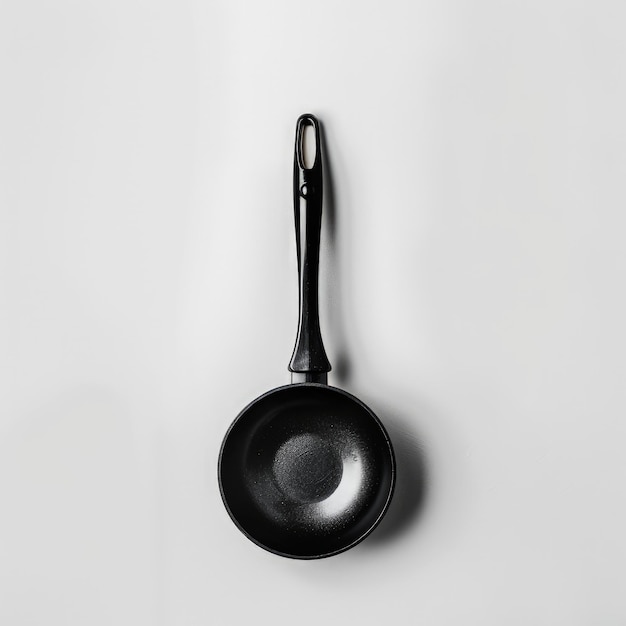 a black frying pan hanging on a wall with a black handle