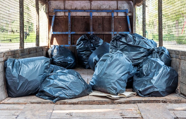 Black garbage bags on back of garbage truck