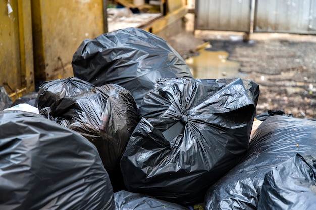 Black garbage bags and blurred dirty wet floor background