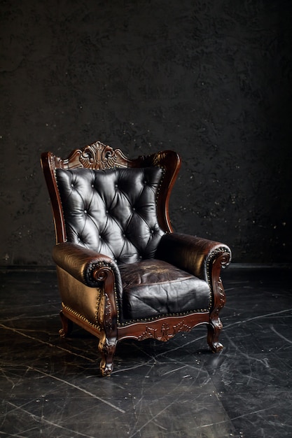 黒い部屋の黒い本革のクラシックスタイルのソファ