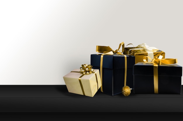 Black gifts with gold ribbons. Christmas gift boxes on black background. Merry Christmas and Happy Holidays greeting card, frame, banner. black friday