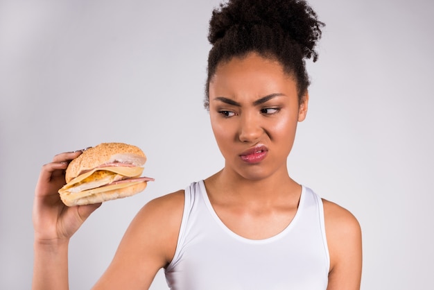 Black girl holding cheeseburger isolated.