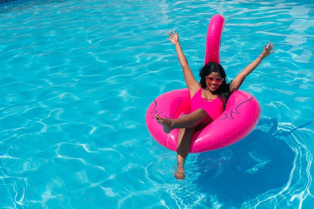 Black girl in the pool relaxing in an inflatable