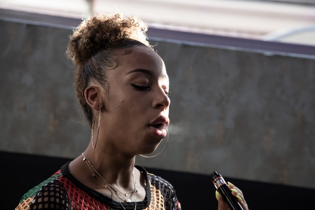 Black girl smoking with a steamer