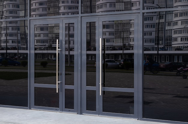 Black glass doors reflecting block of flats standing in the opposite side