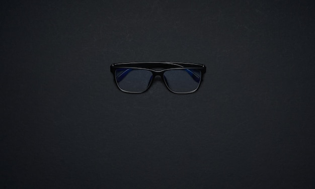 Black glasses isolated on black background . Flat lay and top view with copy space .