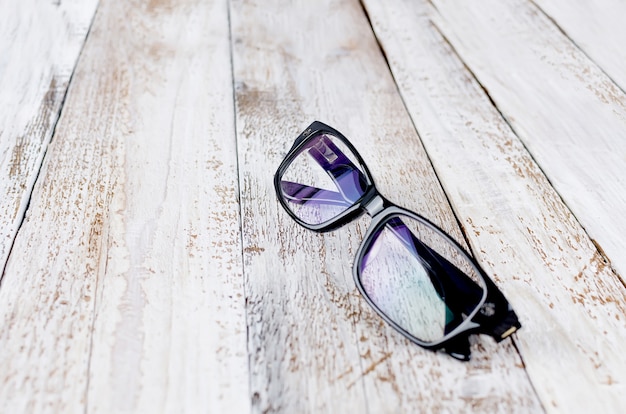 Black glasses on wooden background