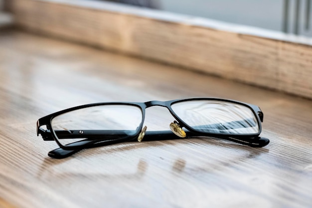 Black glasses on a wooden table closeup