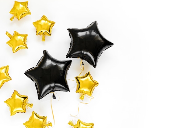 Black and gold foil balloons of stars shaped. Holiday and celebration concept. Birthday Day or party decoration. Metallic air balloons.
