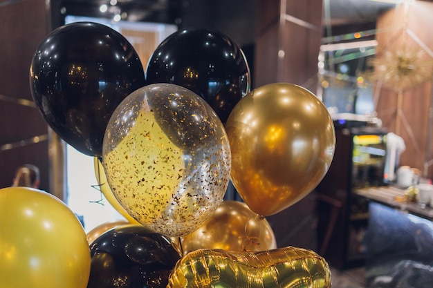 Black and gold helium air balloons on white background celebrate party