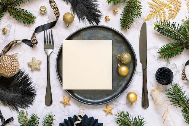 카드 장식품과 전나무 나뭇가지가 있는 검은색과 황금색 크리스마스 테이블 설정