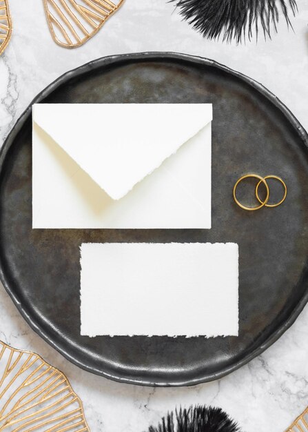 Photo black and golden wedding table setting with a blank card and envelope top view mockup