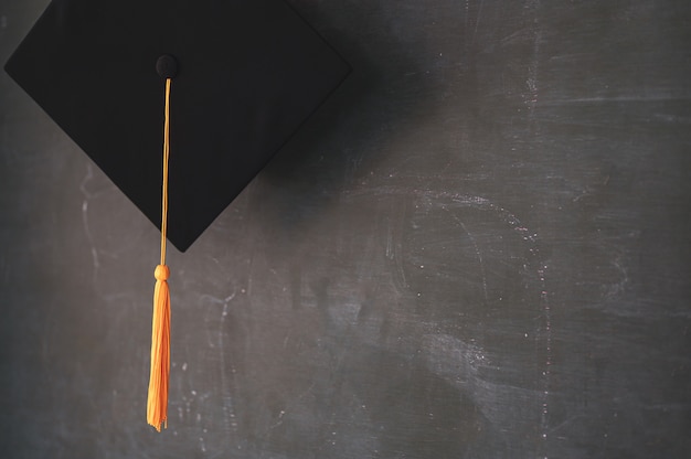 Photo black graduates hat hung on the blackboard