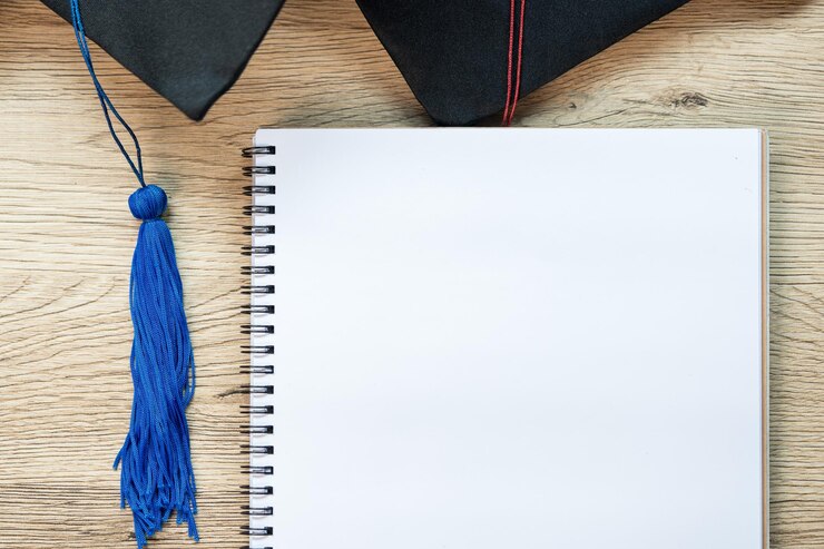 Black graduation cap and notebooks on Wood Background concept of graduation
