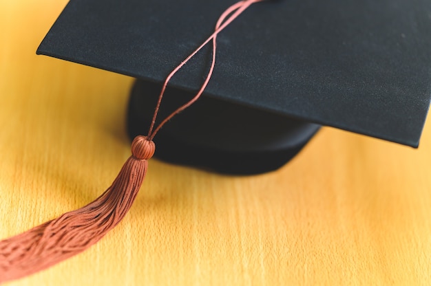 Black graduation cap placed on a wooden table