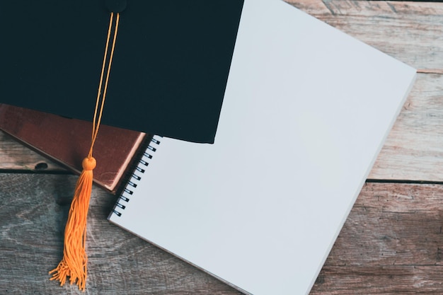 Black graduation hat and book notebook placed on a wooden table\
ideas ideas graduation