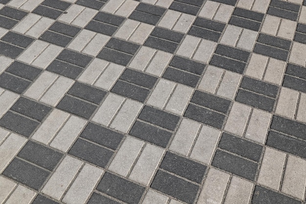 Black and gray paving slabs on the sidewalk in the city as a background