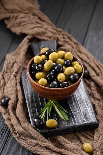 Black and green olives on a dark wooden black background