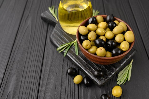 Black and green olives on a dark wooden black background