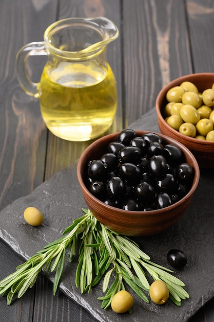 Black and green olives on a dark wooden rustic background