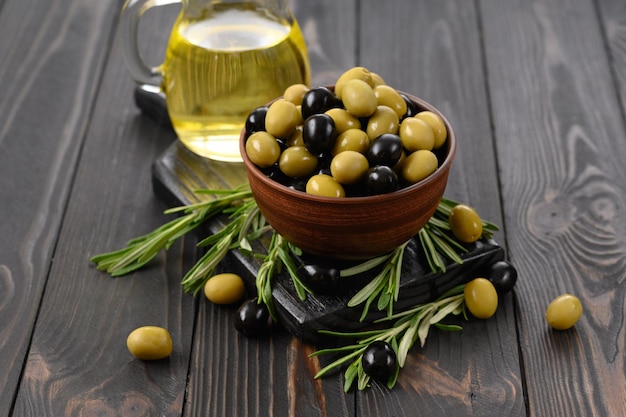 Black and green olives on a dark wooden rustic background