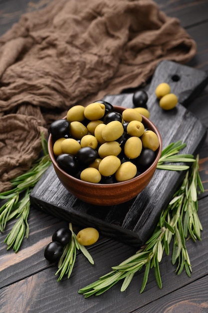 Black and green olives on a dark wooden rustic background