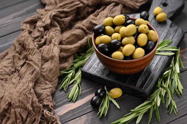 Black and green olives on a dark wooden rustic background