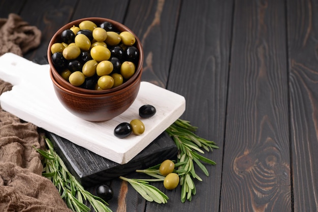 Black and green olives on a dark wooden rustic background