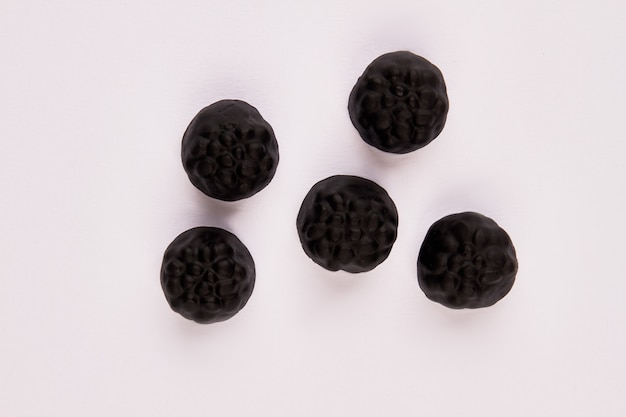 Black gummy candies on white background black jelly sweets jelly treats for halloween party