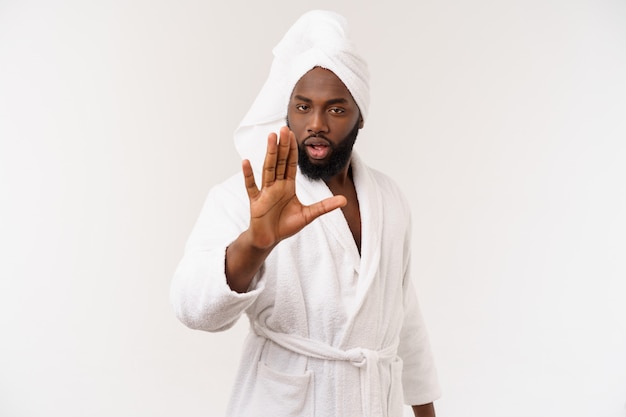 Black guy wearing a bathrobe pointing finger with surprise and happy emotion.