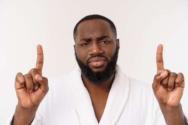 Black guy wearing a bathrobe pointing finger with surprise and happy emotion.