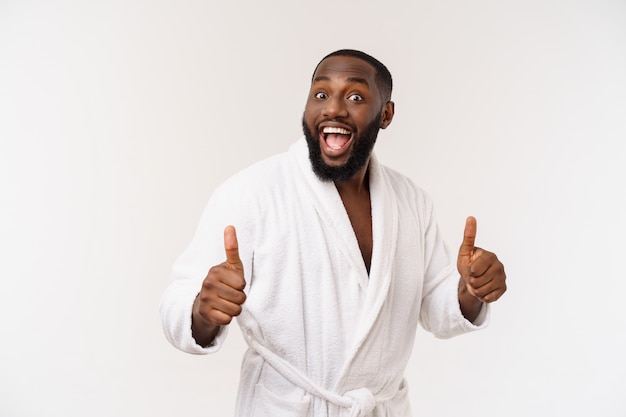 Black guy wearing a bathrobe pointing finger with surprise and happy emotion. 