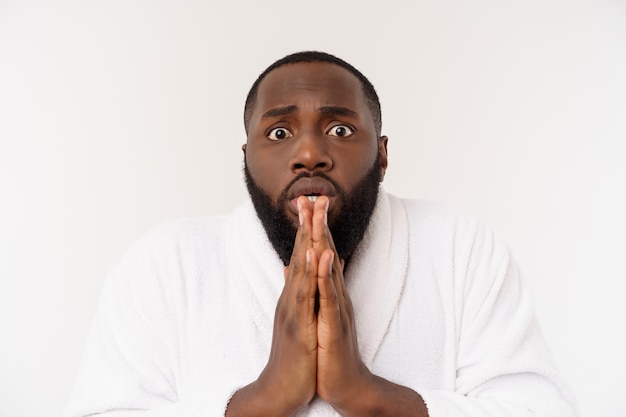 Black guy wearing a bathrobe pointing finger with surprise and happy emotion. 